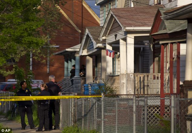 Prison: Cleveland Police stand outside a home where the trio spent more than a decade in captivity 